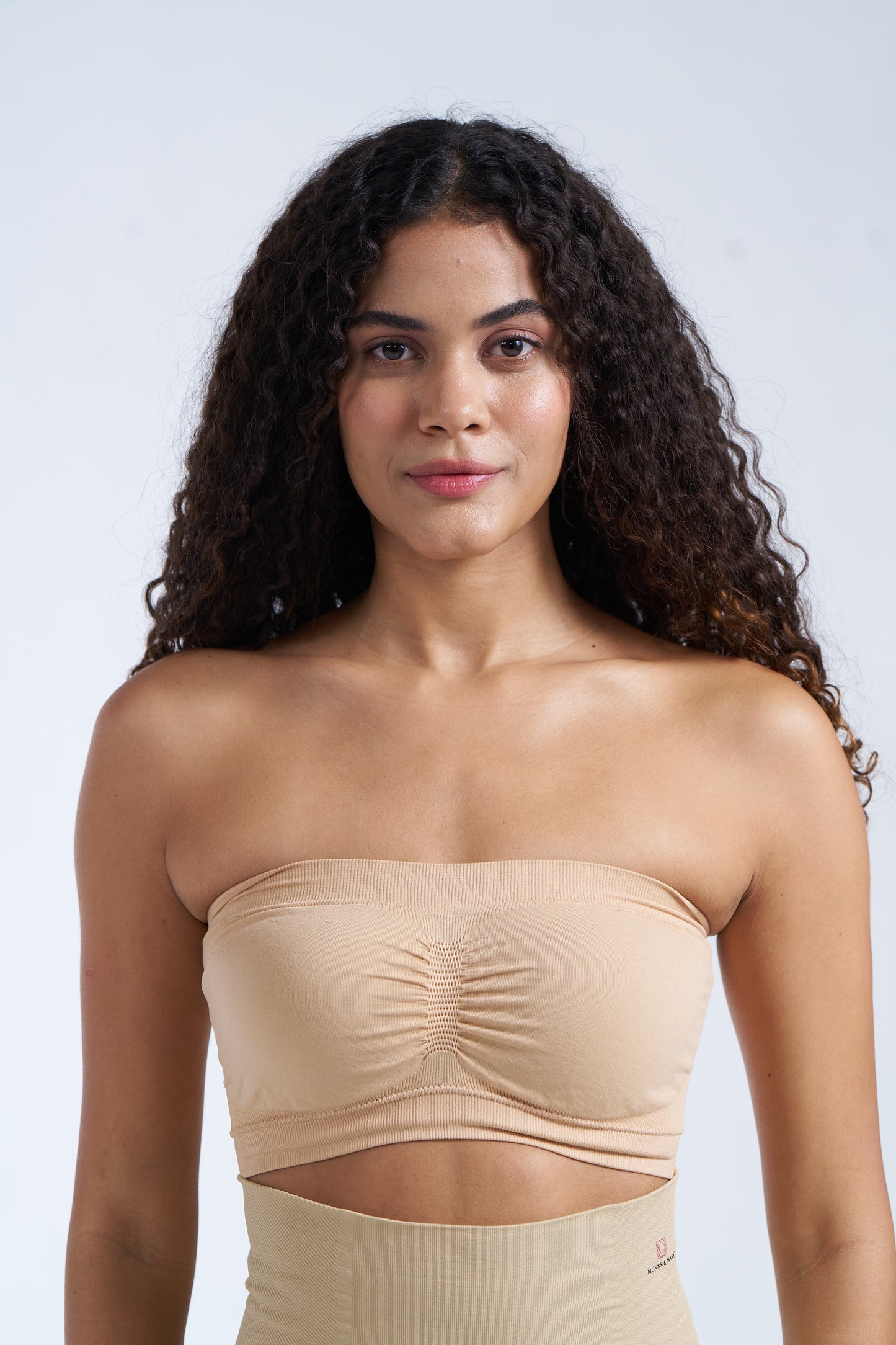 A woman wearing a beige seamless tube bra.